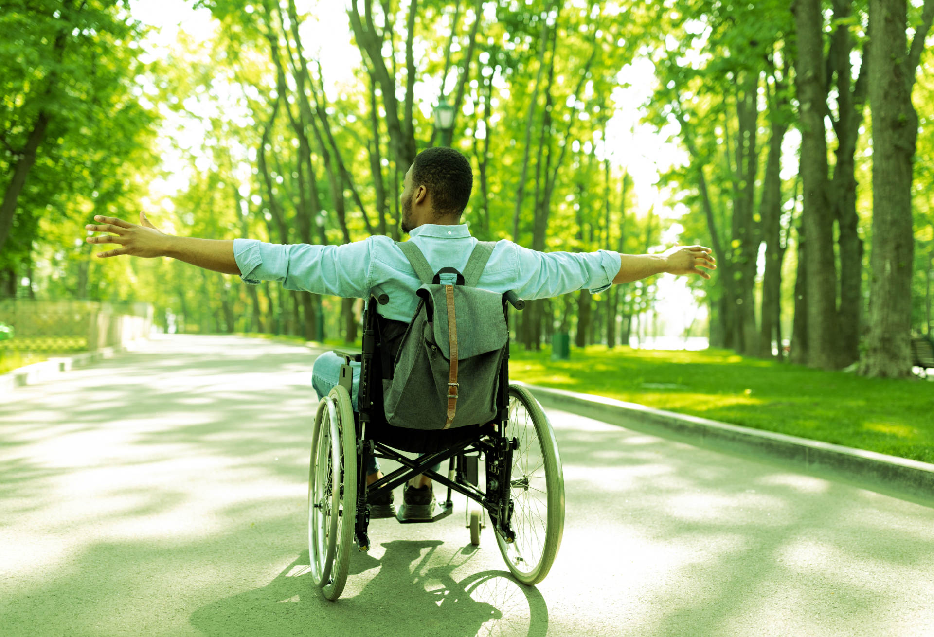 Man in a wheelchair embracing freedom in a park